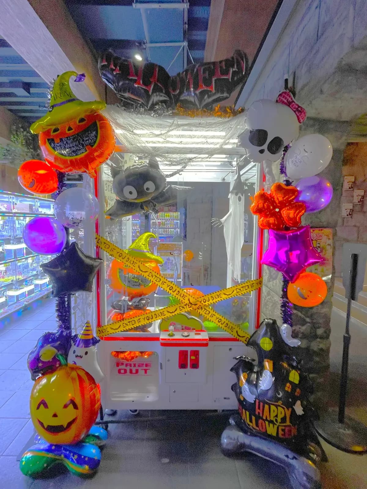 バルーンとイエローテープで飾られたハロウィン仕様のクレーンゲーム